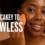 African American woman applying foundation on textured skin for smooth finish.