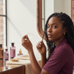 Melanin-rich Black woman with rich brown skin and textured hair in a warm editorial scalp-care moment for Hair Shedding vs Breakage on Natural Hair: How to Tell the Difference