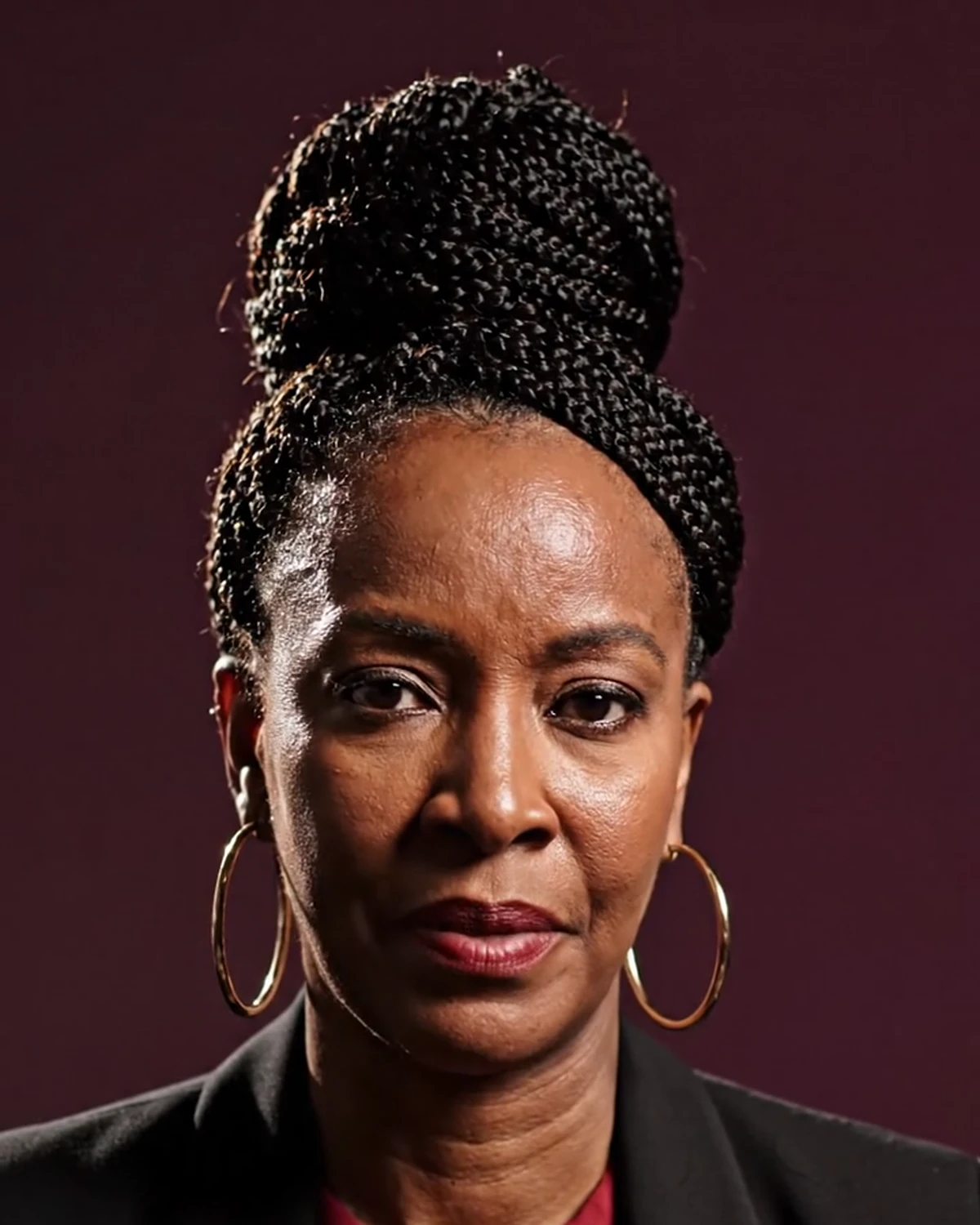 Poised Black woman in dark burgundy and soft gold light representing self-worth after not being chosen