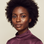 Black woman with rich brown skin in an editorial portrait for post-inflammatory hyperpigmentation timeline on deep skin